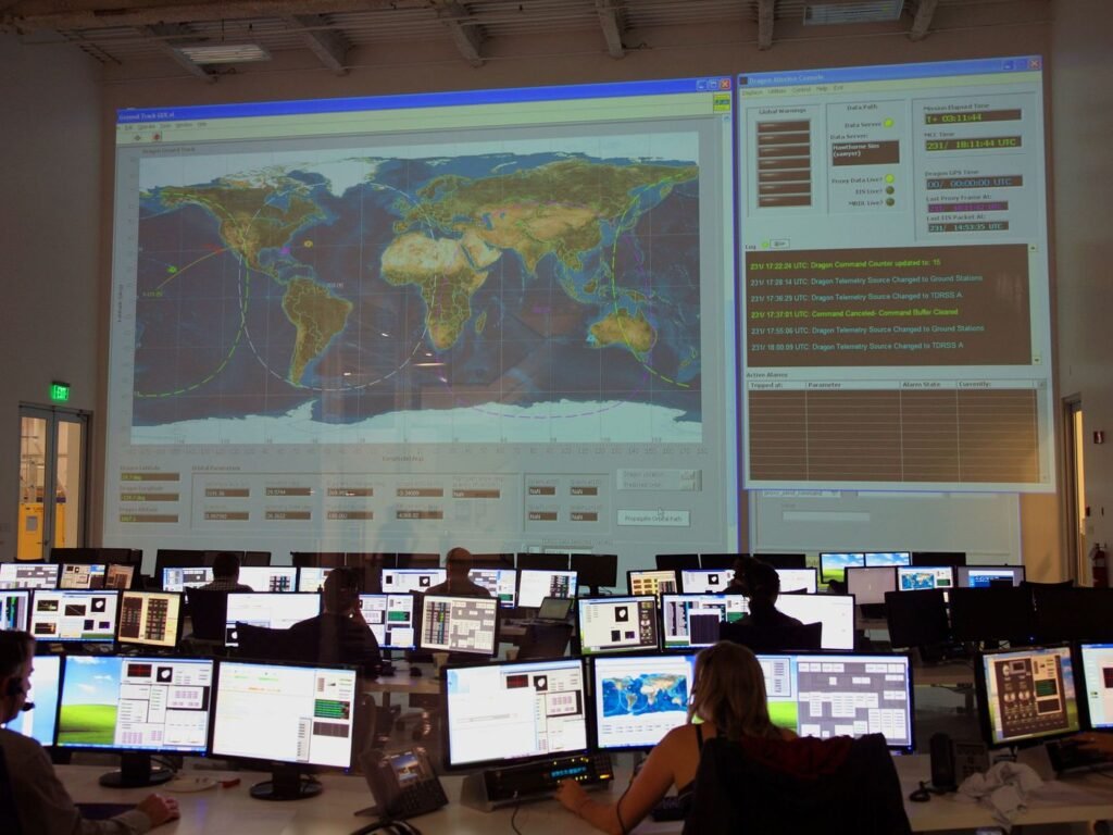 Sala de monitoramento com operadores acompanhando telas e um mapa em painel